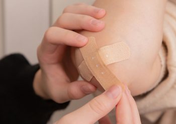 Person applying a band aid illustrating DevOps platform GitLab issuing new critical security patches following a streak of vulnerabilities that could impact organisations and software developers.