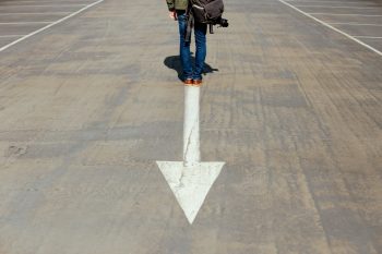 Person standing on a downward arrow suggestive of platform engineering falling short of expectations in embedded software.